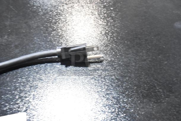 Power plug of Hatco Flav-R-Savor FSDT-2X cabinet, 120 volts. Black cord on a reflective surface.