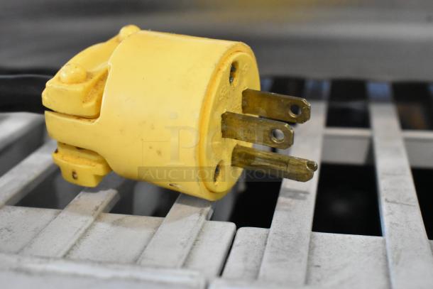 A yellow power plug for a Ditting KFA 903 coffee grinder, showing a three-prong configuration and signs of wear.