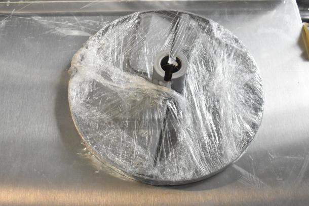 3 new scratch and dent items: 2 vegetable slicer blades, 1 Robot Coupe food processor blade, partially wrapped in film.