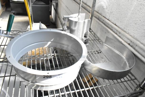 3 new items on a metal rack: 2 Garde vegetable slicer parts and a metal collar, showing minor scratch and dent. Marked "298 QTY 3X."