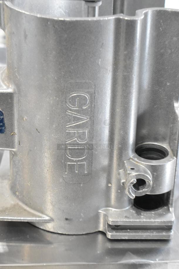 Brand new Garde vegetable slicer parts; scratch and dent condition, with metal collar. "GARDE" logo visible.