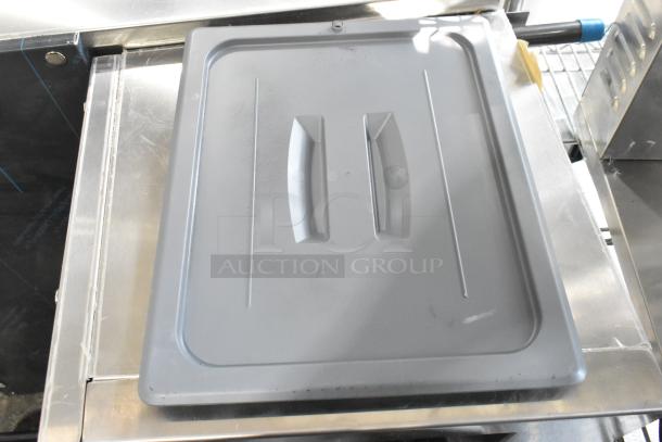 Gray handled lid for Cambro 20CWCH135, in new condition, lying on a stainless steel surface.