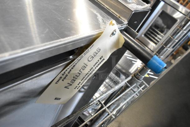 Brand new Garland stainless steel natural gas cheese melter with backsplash, scratch and dent condition, visible gas tag.