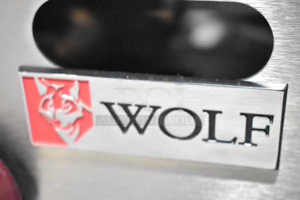 Close-up of Wolf logo on a stainless steel finish from the AHP848-1 8 burner commercial range.