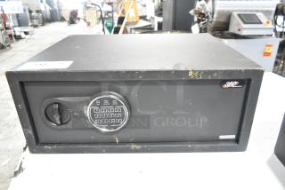 Brand new 360 Office Furniture black steel safe, 19 3/4" x 16" x 7 7/8", with electronic keypad; minor scratches.