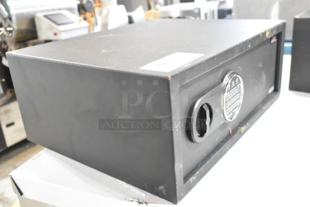 Black steel security safe, 19 3/4" x 16" x 7 7/8", electronic keypad lock. New, with minor scratches and dents.