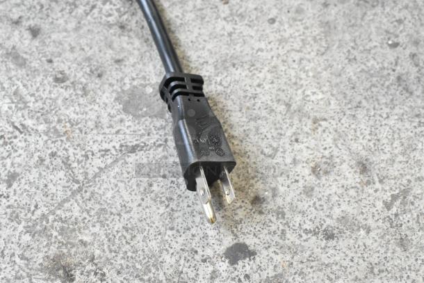 Three-prong power plug on concrete floor for Bizerba GSE 12 slicer, 120V, 1-phase. Plug and cord appear new.