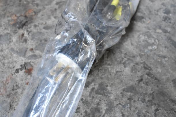 Plastic-wrapped power cord for ServIt 423HDM26SA heated display case, visible prongs, on concrete surface.