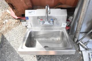 Stainless steel single bay sink with faucet and handles, featuring NSF label. Surface shows signs of use.