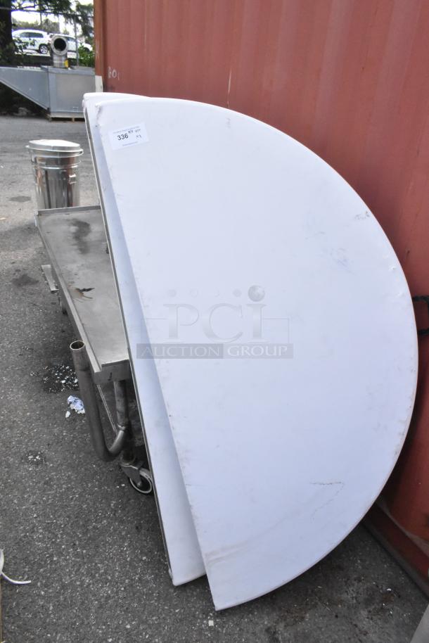 White round folding table in folded position, visible scuff marks, auction tag labeled "336."