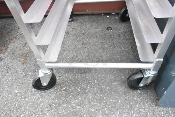 Brand new Regency 600PPR13KD2 13-pan pizza dough box rack on commercial casters with visible scratches and dents.