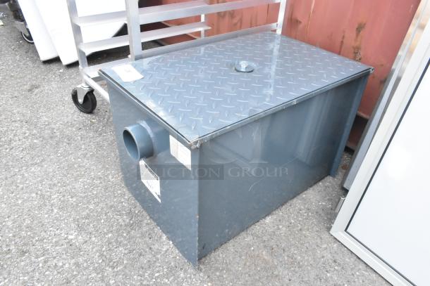 Brand new Watts WD-25 50 lb. grease trap, scratch and dent condition, gray metal with diamond plate top, labeled.