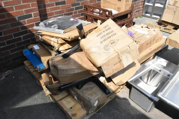 18 new scratch and dent items on pallets, including stainless steel equipment stand and table base plates in damaged boxes.