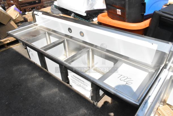 BRAND NEW Regency 600S31515215 stainless steel 3-bay sink with dual drain boards, scratch and dent, no legs, tag visible.