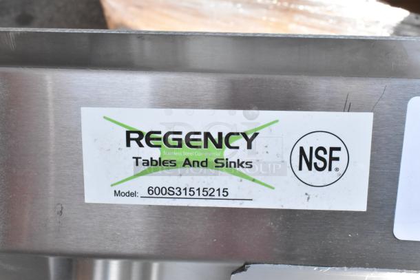 Regency 600S31515215 stainless steel 3-bay sink, new scratch and dent, dual drain boards, no legs, NSF label visible.