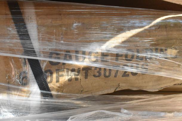 Clear-wrapped package showing part of the text "CAUTION" and "FOLDING," indicating a boxed folding item inside.