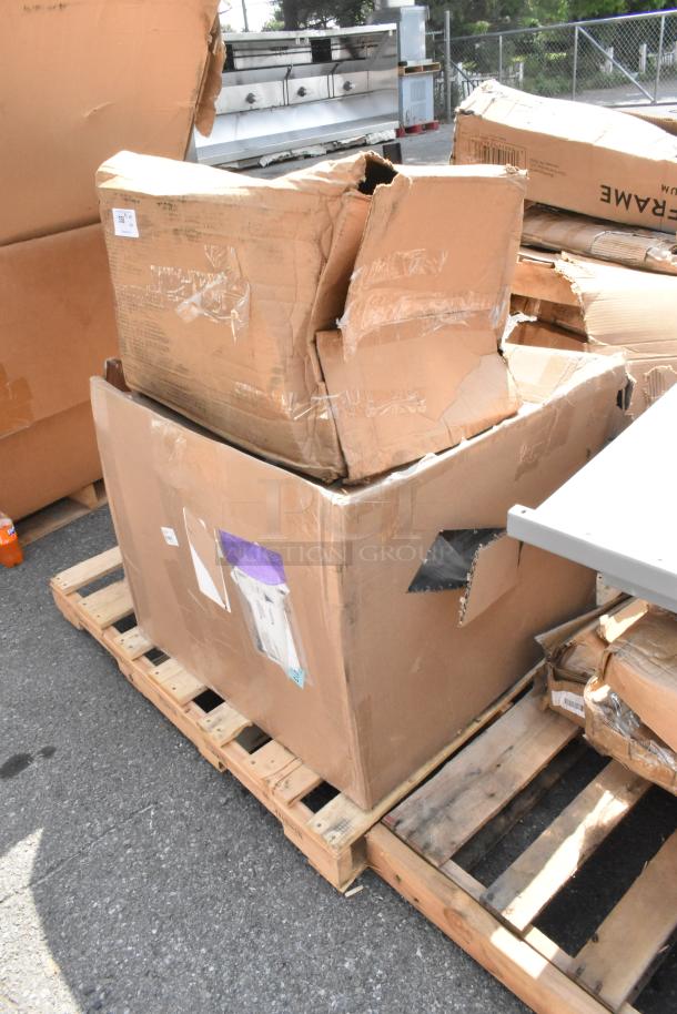 4 Brand new scratch and dent items in damaged boxes, including Steelton sink, cutting boards, and pizza pan on pallet.