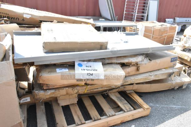 8 new scratch and dent stainless steel equipment stands and tables on pallets; visible boxes show wear. Tags: "Model ES-303".