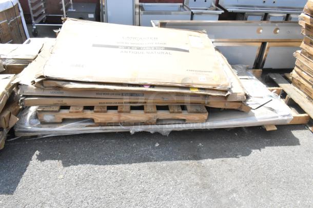 Six brand new scratch and dent items including traffic door, Lancaster tabletops on pallets, in original packaging.