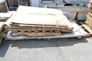 Six brand new scratch and dent items including traffic door, Lancaster tabletops on pallets, in original packaging.