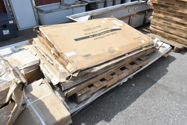 Stack of brand new Lancaster solid wood tabletops, visible labels indicate "30" x 48" table top, Antique Natural."