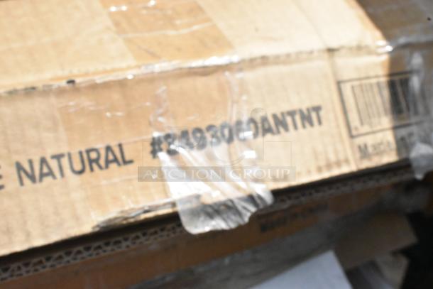 Cardboard box with visible label "#849300ANTNT" containing new scratch and dent items, including traffic door and tabletops.