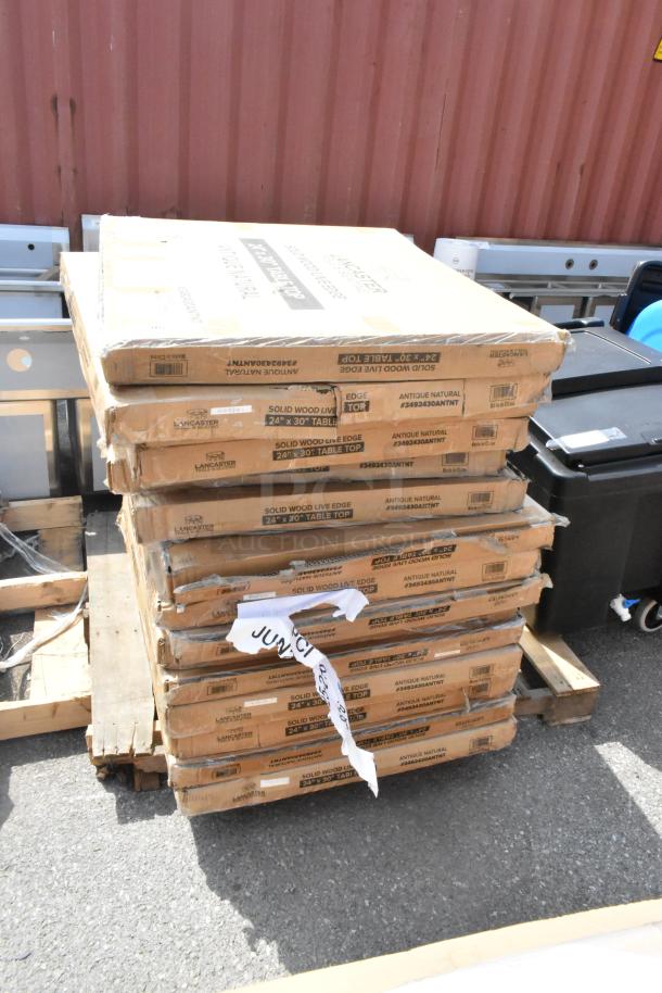 15 new scratch and dent Lancaster 24"x30" solid wood table tops with honey maple finish, stacked in packaging.