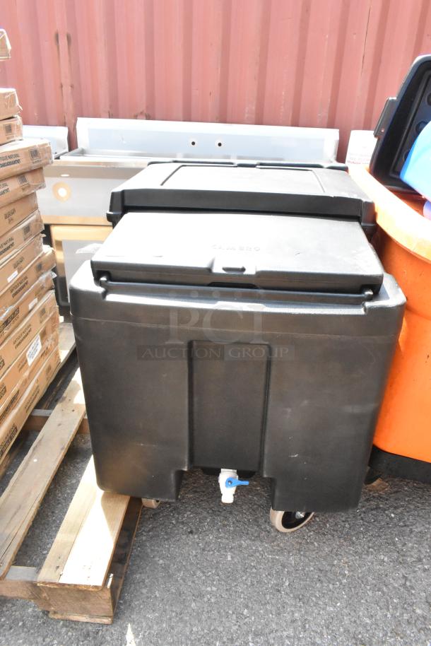 Brand new black poly portable ice bin with commercial casters, slight scratches, labeled "Cambro," visible drain tap.