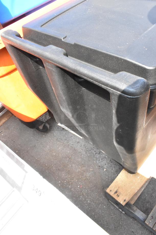 Black poly portable ice bin, brand new with scratches, on commercial casters for easy mobility.