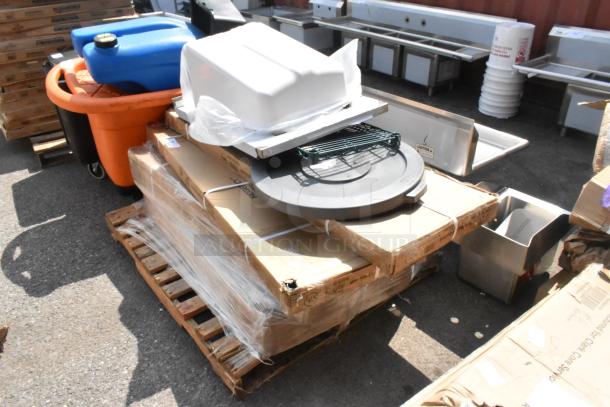 Nine brand new scratch and dent items including wire shelves, stacked on a pallet, wrapped in plastic for auction.