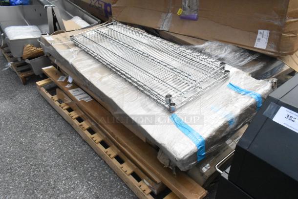 Eight brand new scratch and dent items, including a stainless stable, pan rack, and posts, bundled on pallets.