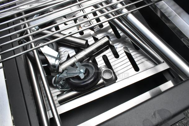 Brand new Backyard Pro 554SMOKR60AS 60" smoker grill components, showing adjustable grates and caster wheels.