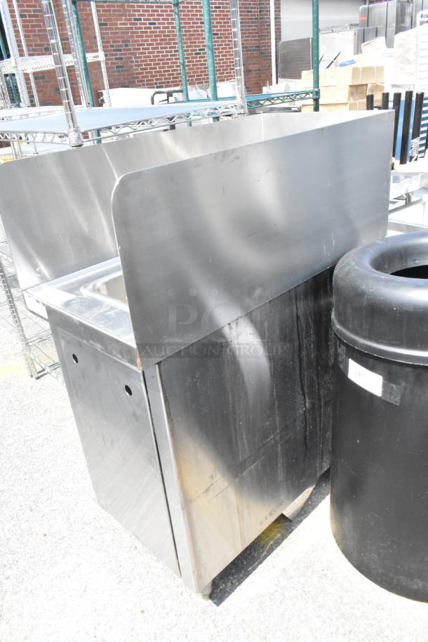 Stainless steel single bay sink with faucet, handles, and side splash guards, showing minor wear, ideal for commercial use.
