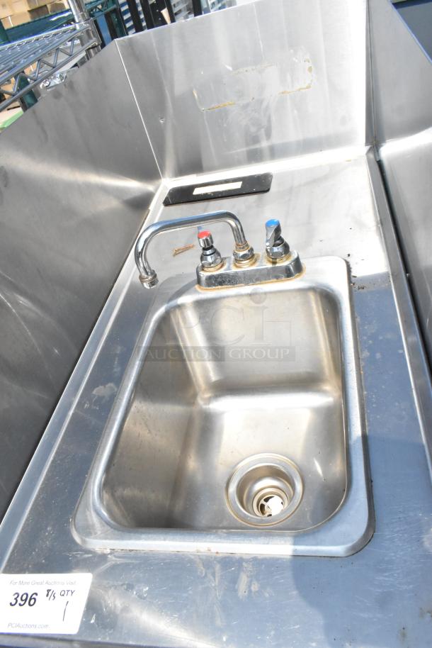 Stainless steel single bay sink with faucet, handles, and side splash guards, showing minor wear and label "396 T/S QTY 1".