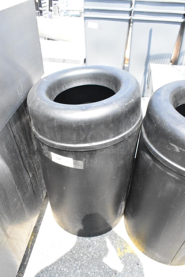 Two black trash can shells, cylindrical with open tops. Visible wear, label marked "397". Auction lot, double bid value.