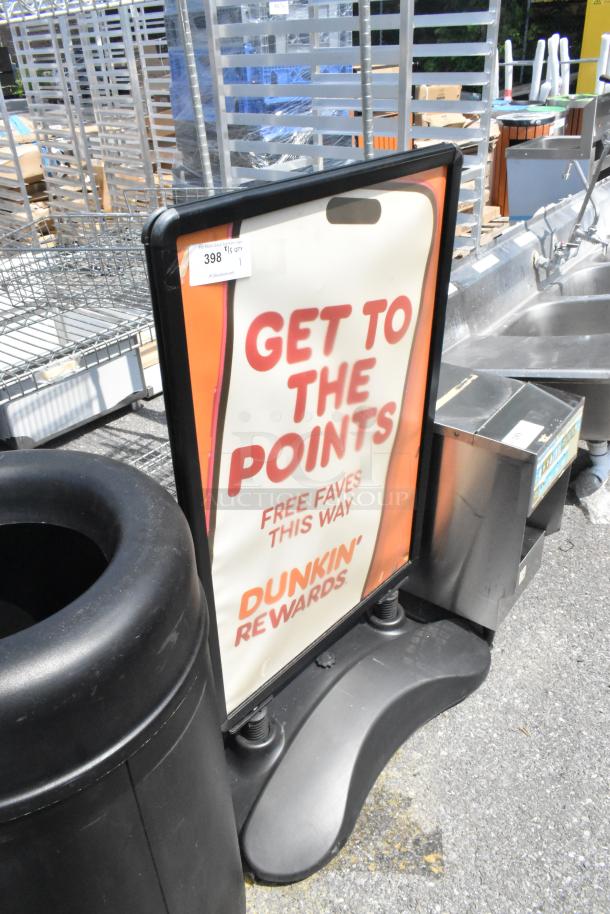 Black sidewalk sign featuring a "Dunkin' Rewards" promotional poster, in good condition with visible sturdy base.