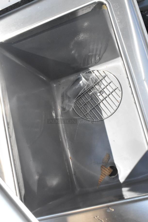 Stainless steel drop-in ice bin and water dispenser, brand new condition with minor scratches and dents, visible interior grate.
