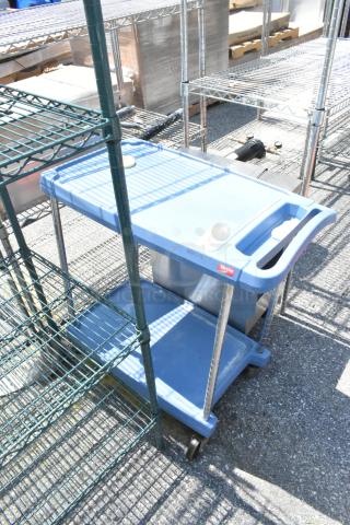 Metro Blue Poly 2 Tier Cart with commercial casters, new condition. Sturdy blue shelves, handles for easy transport.