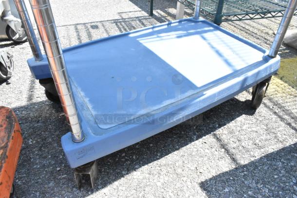 Metro Blue Poly 2-Tier Cart with commercial casters, sturdy metal poles, light wear, ideal for industrial use.