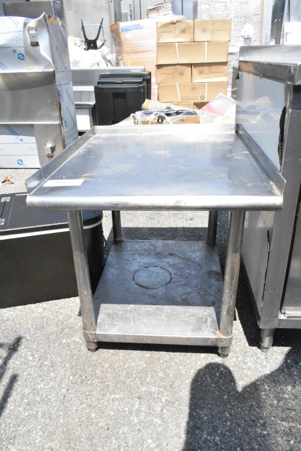 Stainless steel equipment stand with metal under shelf, in used condition, featuring sturdy legs and a flat top surface.
