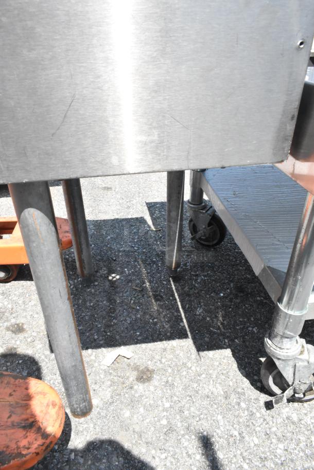 Stainless steel single bay sink with faucet and handles, in good condition, features sturdy legs and bold finish. Ideal for kitchens.