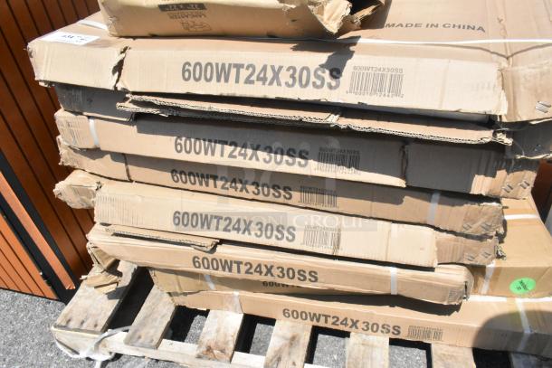 11 new scratch and dent boxes of Regency 600WT24X30SS stainless steel work tables on pallet; visible box damage.