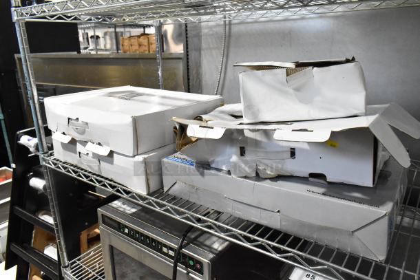 Lot of Lorex surveillance equipment in original packaging on metal shelf, including digital recorder and cameras. Boxes show wear.