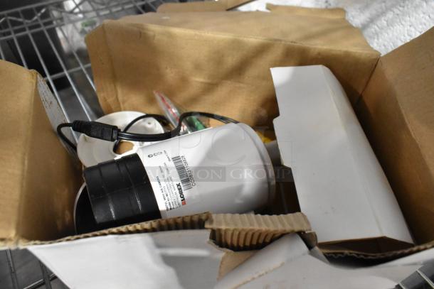 Lot of Lorex security items in a box, includes cameras and recorder. Labels show model numbers and specifications.