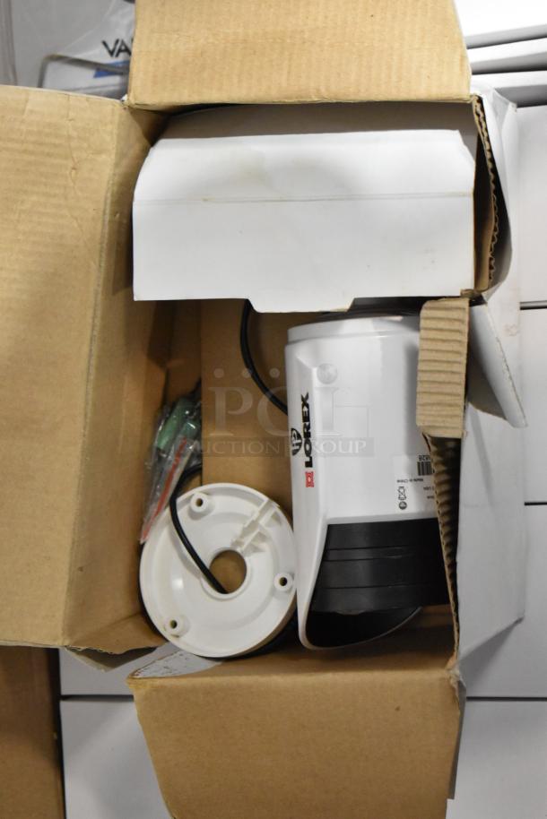Lot of Lorex digital video recorder and 9 security cameras in opened box. Cameras appear unused, some accessories visible.