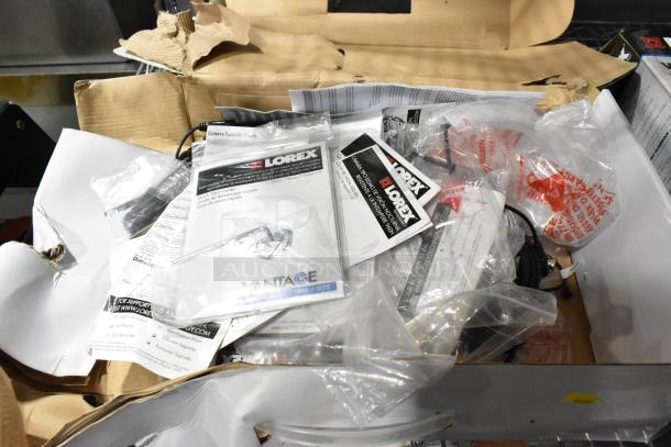 Lot of Lorex DVR and 9 security cameras in open box. Includes manuals and cables. Appears new, some packaging present.