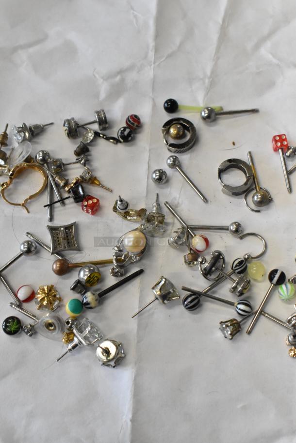 Lot of various jewelry including mixed earrings, necklaces, and a ring. Features metal and bead designs in assorted styles.