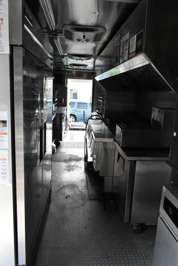 Fully outfitted food trailer interior with stainless steel appliances, ventilation hood, and detailed fixture list. Ready for use.