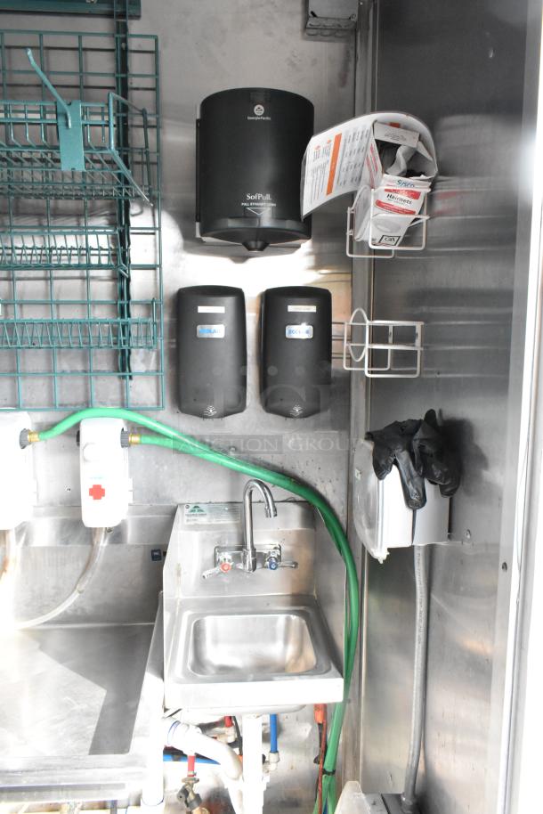 Fully equipped food trailer interior with stainless steel hand sink, Ecolab dispensers, SoFPull paper dispenser, and storage racks.