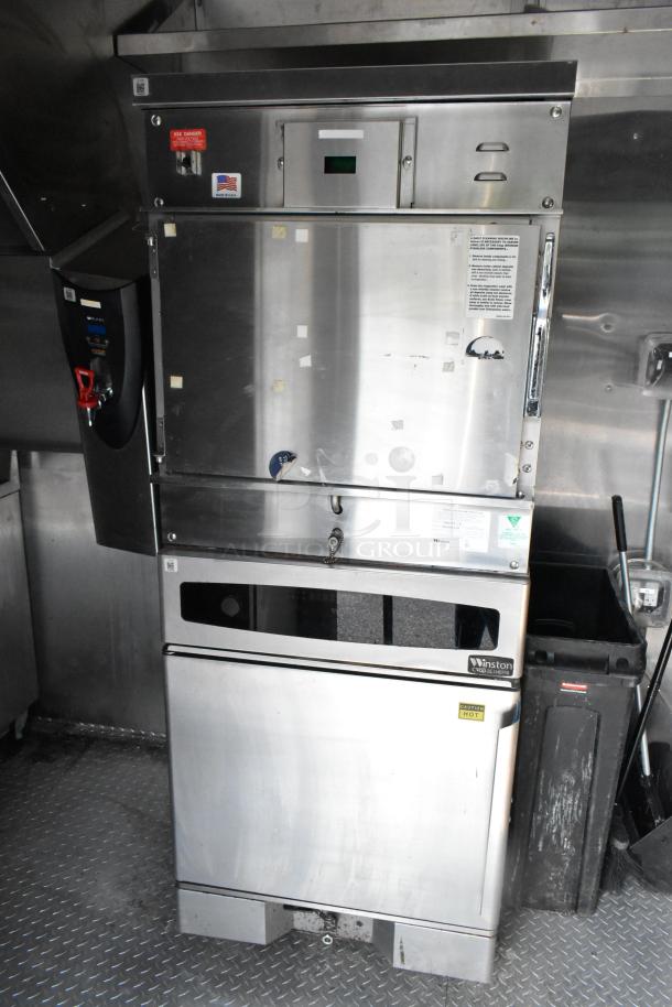 Fully equipped food trailer interior with stainless steel appliances, including a Winston CVap holding cabinet. Visible cautionary labels.